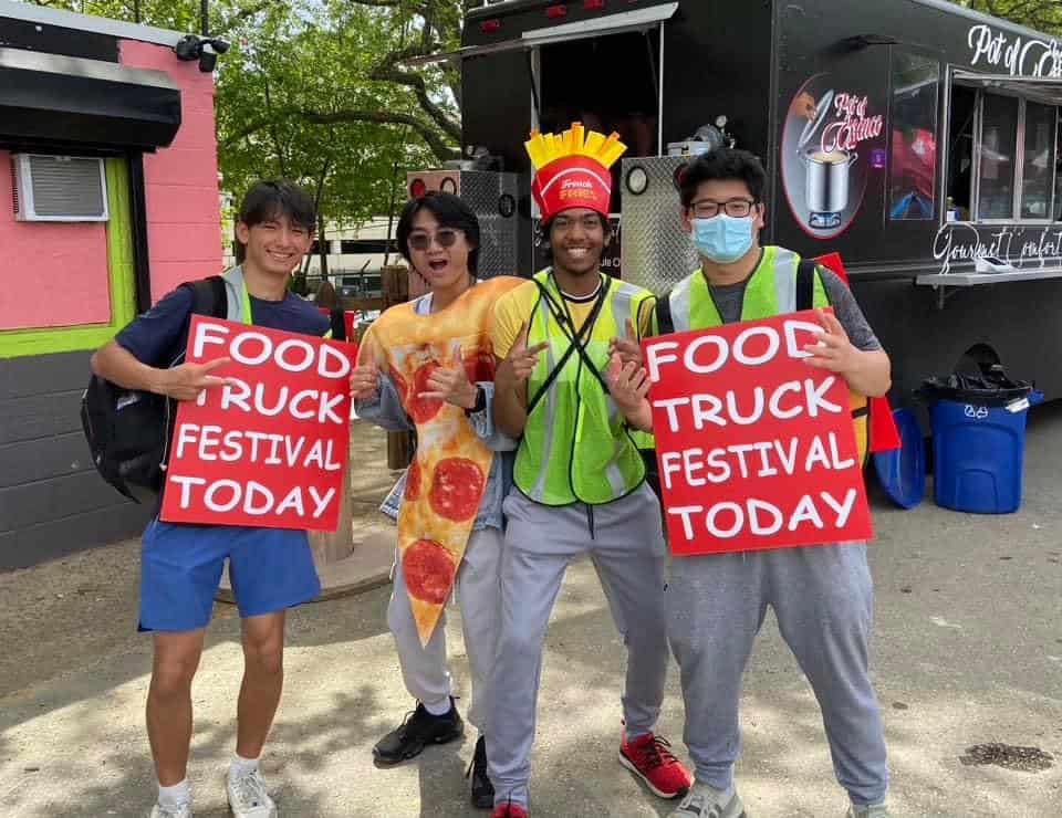 Kids at the Cherry Hill Food Truck Festival raise signs promoting it. The festival raised $5,000 for Kamp for Kids. (Special to The Sun)