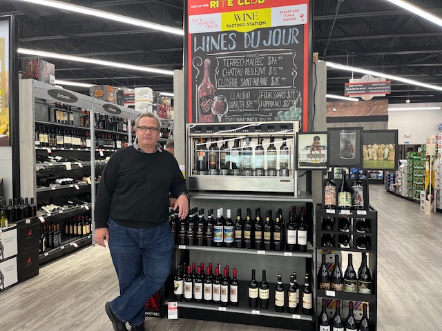 Trevor Dunn, GM of Super Buy Rite at Moorestown Mall, stands next to a wine-tasting stand inside the shop that had its grand opening last October.